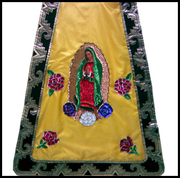 Capa azteca color amarillo con adornos de la Virgen de Guadalupe.